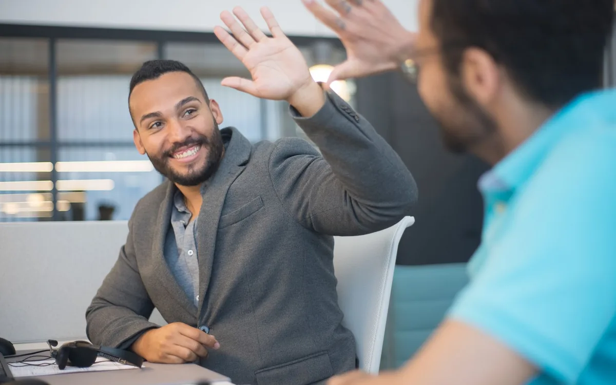 Teamleden geven elkaar een high-five tijdens een buitenactiviteit.